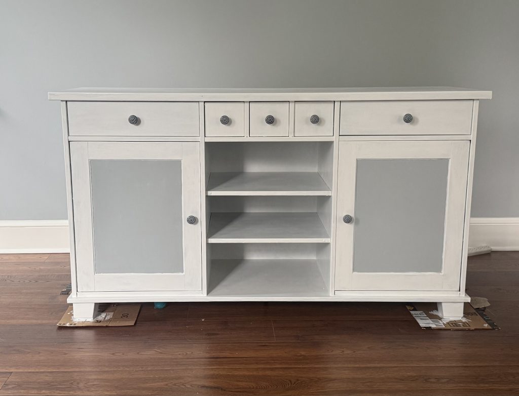 Refinished white and gray sideboard with decorative knobs, freshly painted and restored for a modern farmhouse look.